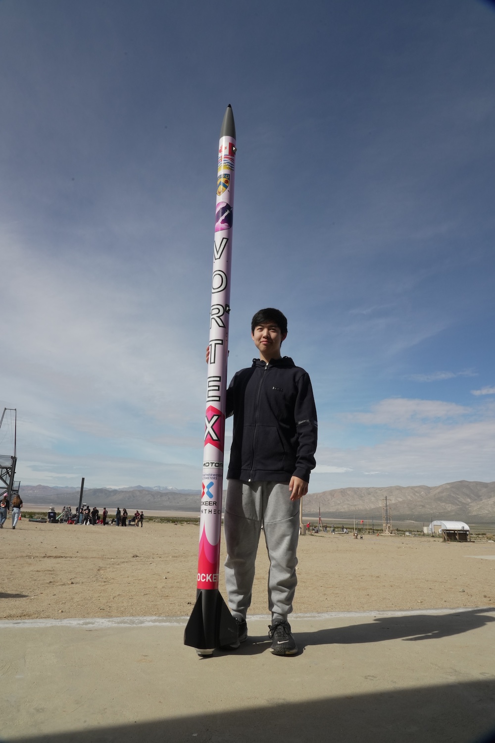 Jason Zhao stands next to the rocket he created to detect and monitor wildfires. 